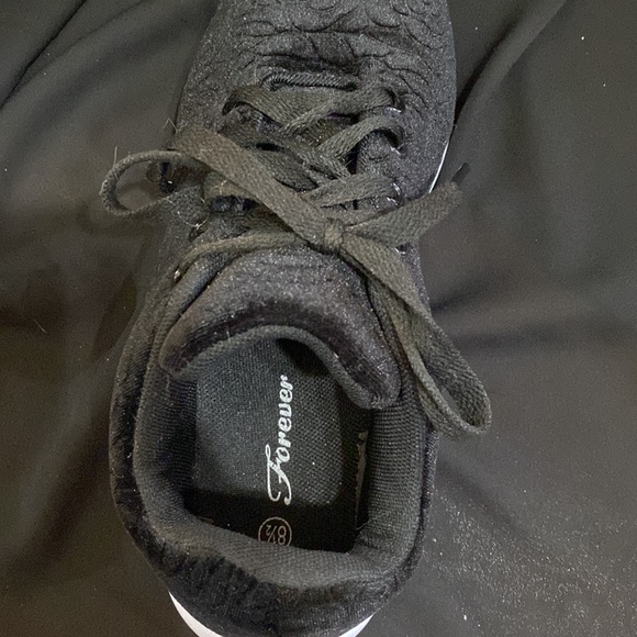 These are black sneakers with a rose design in the cloth on the outside. - Picture 3 of 4